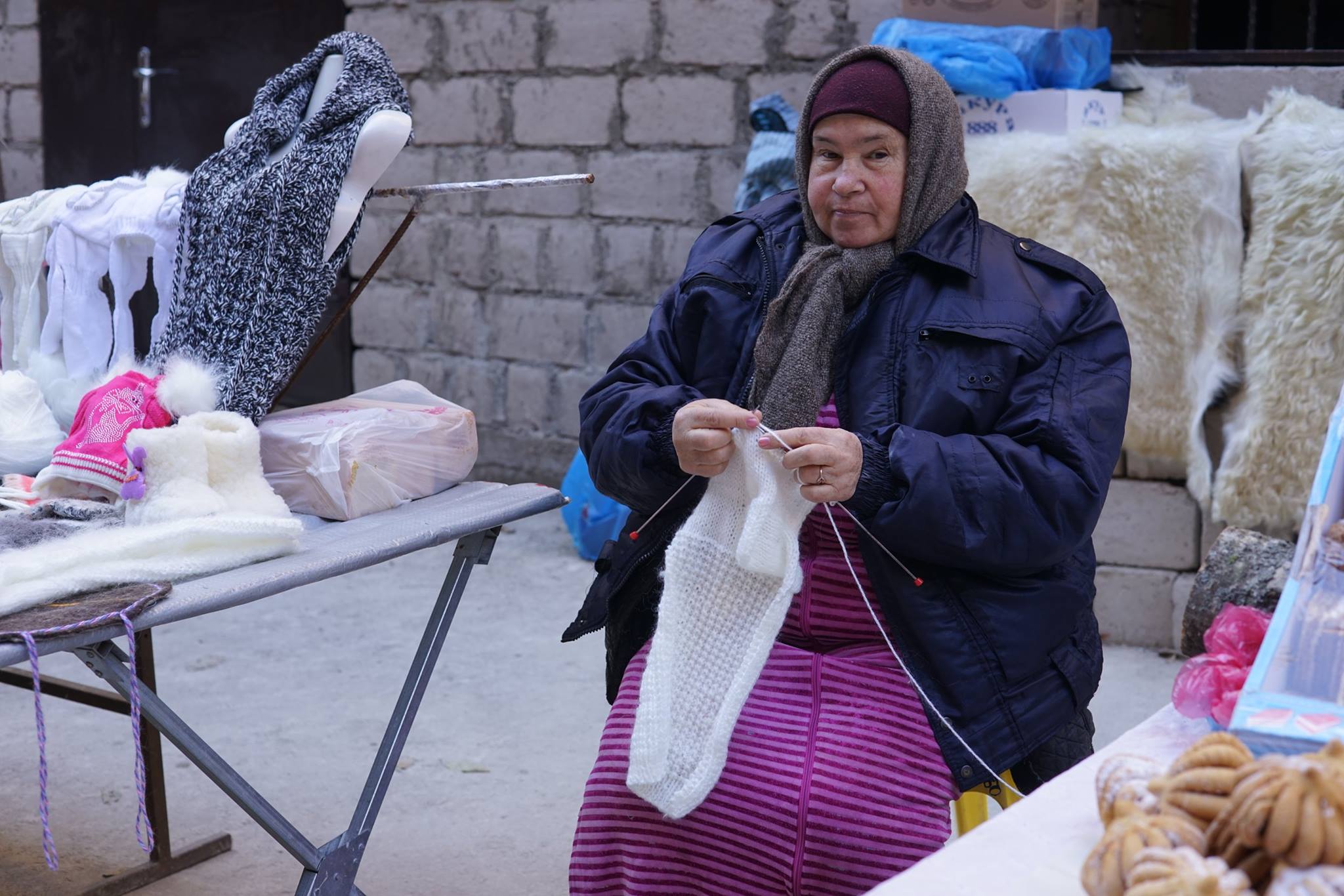 Woman is knitting at the market